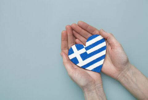 hands holding the Greek flag