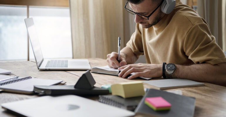 young-man-writing-notebook-study-session